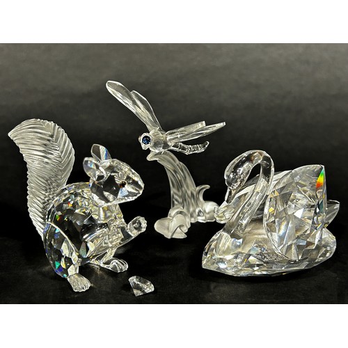 1117 - A small group of Swarovski crystal figures including a dragonfly, swan and a squirrel holding a diam... 