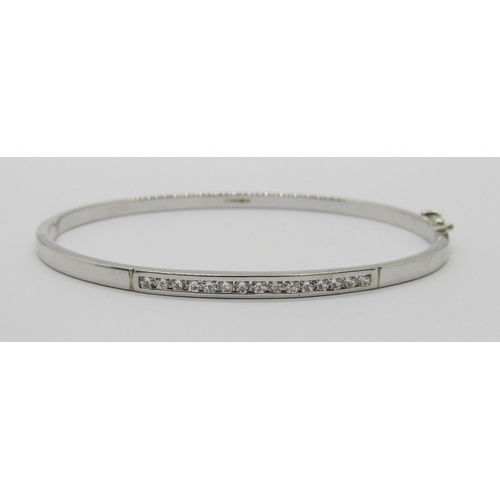 1361 - 9ct white gold hinged bangle channel set with cubic zirconia, 4.4g