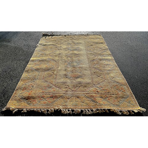 2733 - A Turkish Carpet with a central panel with scrolled medallions and geometric borders on a pale beige... 