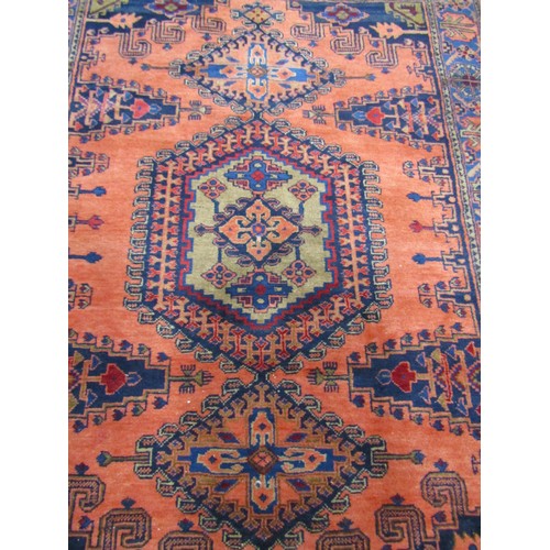 2721 - A Turkish Carpet with a central medallion flanked by two smaller on a predominantly peach ground and... 