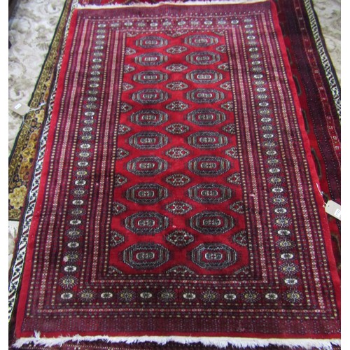 2722 - A Bokhara Carpet with alternating row of guls on a predominantly red ground, 180cm x 125cm.