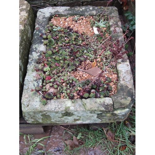 2063 - A shallow but thick walled rectangular natural stone trough, with single rounded corner containing s... 