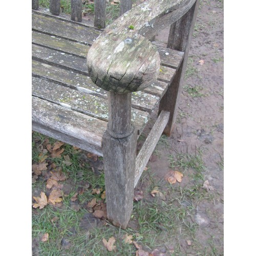 2075 - A weathered teakwood bench with slated seat and back beneath an arched rail, 159cm wide (af)