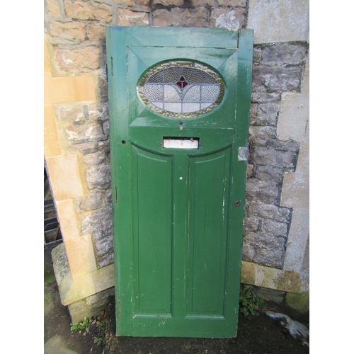 2077 - A 1930s painted front door with oval leaded light panel and irpn fittings, 84cm wide x 198cm high