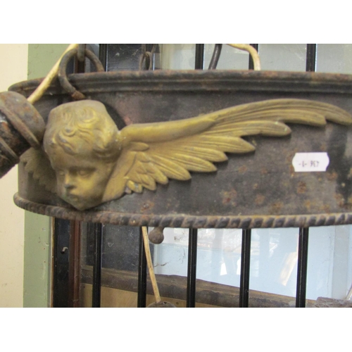 2120 - A run of four large iron work ceiling light fittings with gilt painted highlighted winged cherub det... 