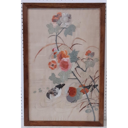 180 - An early 20th century Japanese thread work panel showing mandarin ducks swimming amongst flowers