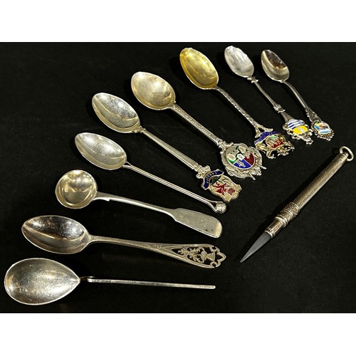 243 - Nine assorted silver souvenir spoons, a silver wine coaster and a pencil casing