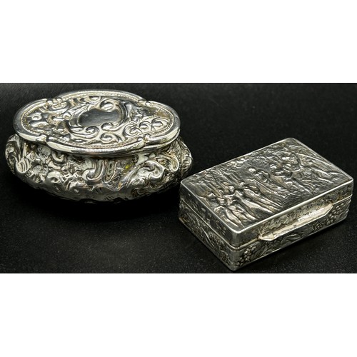 247 - A silver snuff box with classical muses to the lid, together with an oval shaped snuff box with scro... 