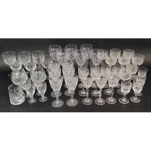 176 - A large suite of mixed cut glass wine glasses in varying styles and sizes