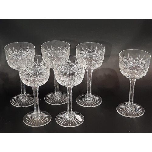 176 - A large suite of mixed cut glass wine glasses in varying styles and sizes