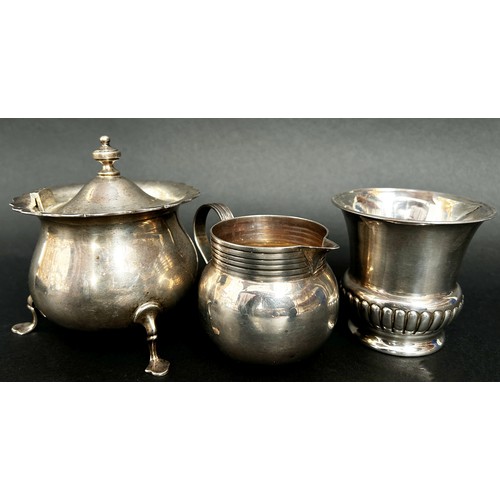 291 - A silver sugar bowl raised on three pad feet, a gadrooned beaker and a cream jug, 11 ozs approximate... 