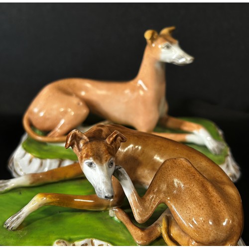 99 - Pair of 19th century continental porcelain hounds on shaped bases with gilded borders