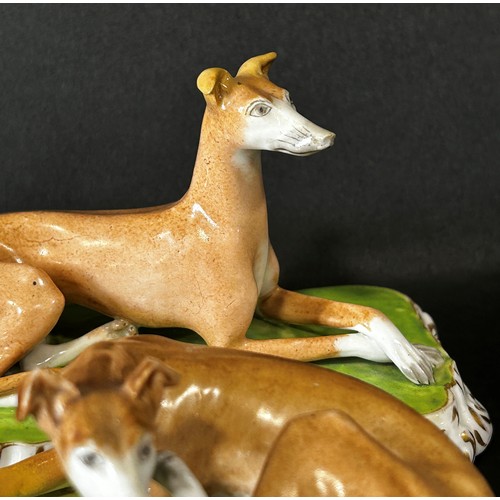 99 - Pair of 19th century continental porcelain hounds on shaped bases with gilded borders