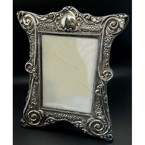 283 - A silver photo frame with a spiral decorative frame 13 x 9 cm opening