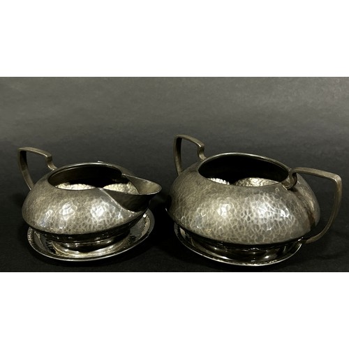 223 - A three piece Tudric Pewter tea service, teapot, sugar bowl and milk jug, all with a lightly hammere... 