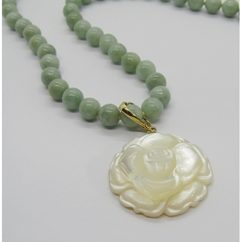 388 - Modern 14k jade bead necklace, hung with a 14k carved mother of pearl flower pendant, together with ... 