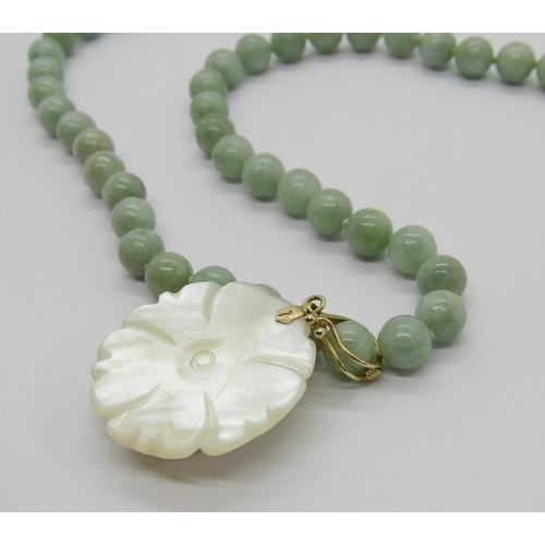 388 - Modern 14k jade bead necklace, hung with a 14k carved mother of pearl flower pendant, together with ... 