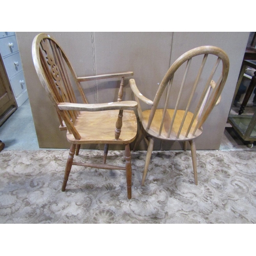 1107 - An Ercol hoop back elbow chair, together with a further Windsor wheelback armchair