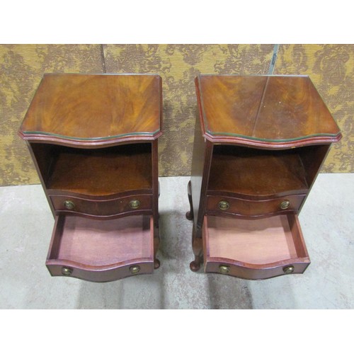 1122 - A pair of reproduction Georgian style bedside/lamp tables, the serpentine front partially enclosed b... 