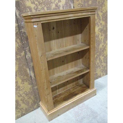 1125 - A stripped pine floorstanding open bookcase with two fixed shelves and moulded plinth, 113 cm high x... 