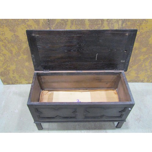 1126 - A dark stained oak blanket box in the Jacobean style with hinged lid over a geometric moulded panell... 