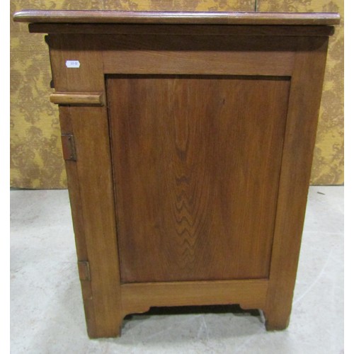 1130 - A continental oak arts and crafts style side cupboard, enclosed by a pair of carved panelled doors w... 