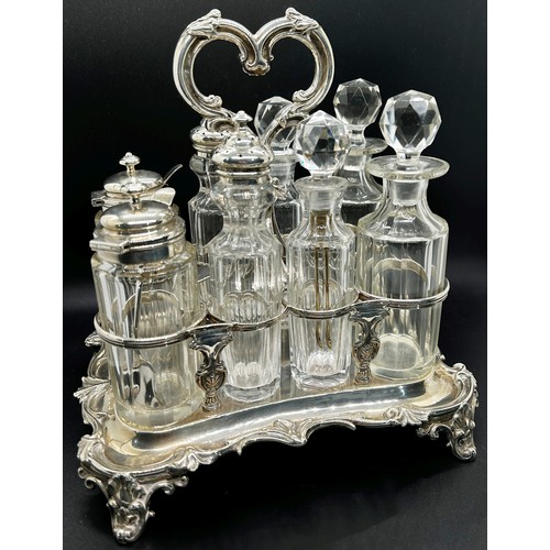 273 - A Victorian silver table condiment stand with eight glass bottles, the oblong scrolled stand is rais... 