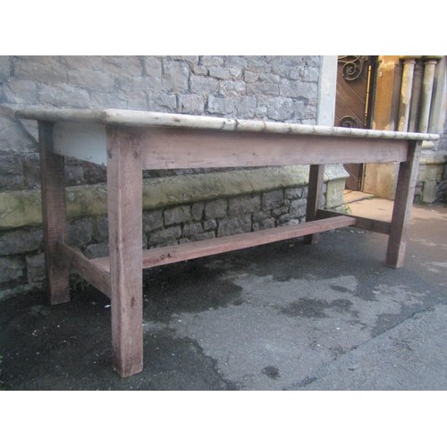 1163 - A rustic pine kitchen table, the rectangular boarded top with split bamboo moulded surround raised o... 