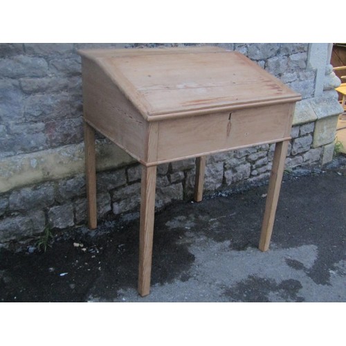 1152 - A stripped pine clerks desk, the hinged sloping lid enclosing a simple pigeon holed interior raised ... 