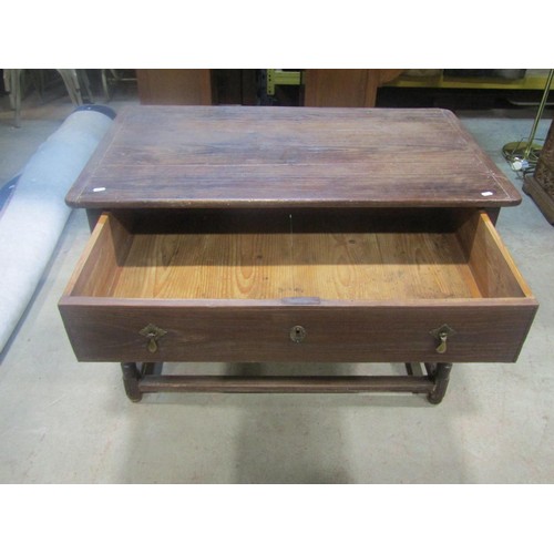 1153 - An antique oak stained pine side table, the plank top with cleated ends over a frieze drawer and tur... 