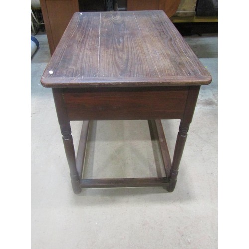 1153 - An antique oak stained pine side table, the plank top with cleated ends over a frieze drawer and tur... 