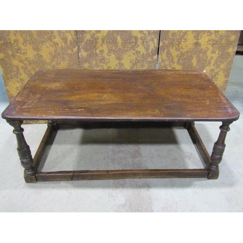 1249 - A low antique oak table of rectangular form with boarded top raised on turned block supports united ... 