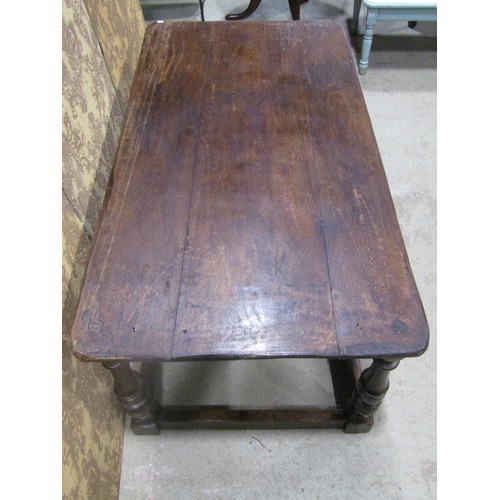 1249 - A low antique oak table of rectangular form with boarded top raised on turned block supports united ... 