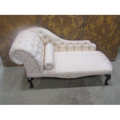 1268 - A small reproduction chaise lounge with upholstered seat and button back raised on cabriole supports... 