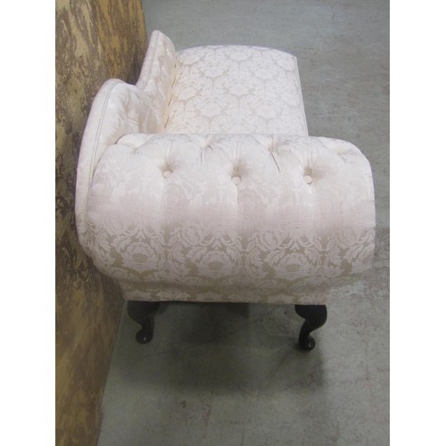 1268 - A small reproduction chaise lounge with upholstered seat and button back raised on cabriole supports... 