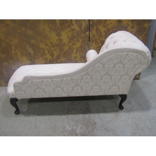 1268 - A small reproduction chaise lounge with upholstered seat and button back raised on cabriole supports... 