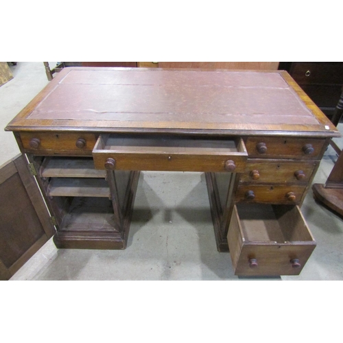 1221 - An oak pedestal desk fitted with six drawers and a cupboard with inset top, 125cm wide