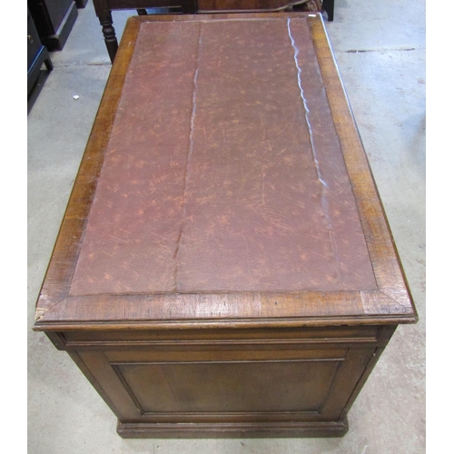 1221 - An oak pedestal desk fitted with six drawers and a cupboard with inset top, 125cm wide