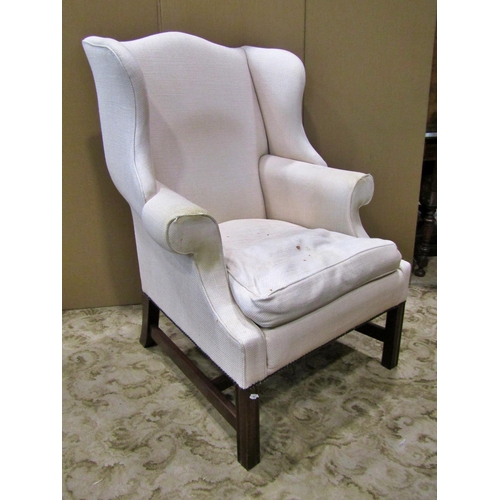 1277 - A George III style upholstered wing elbow armchair, on mahogany supports