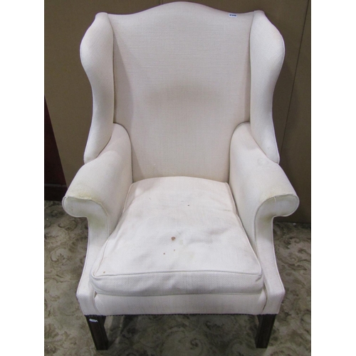 1277 - A George III style upholstered wing elbow armchair, on mahogany supports