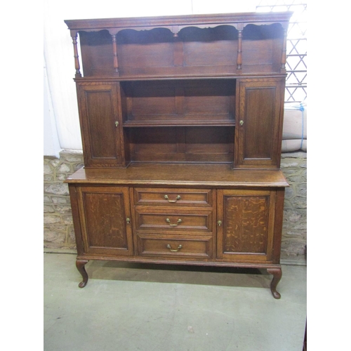 1286 - An Edwardian oak dresser the lower section enclosed by three central doors flanked by two cupboards,... 