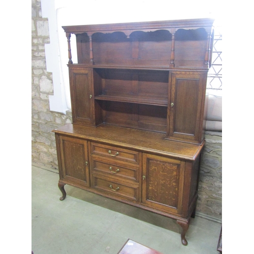 1286 - An Edwardian oak dresser the lower section enclosed by three central doors flanked by two cupboards,... 