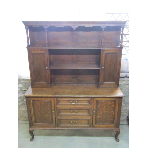 1286 - An Edwardian oak dresser the lower section enclosed by three central doors flanked by two cupboards,... 