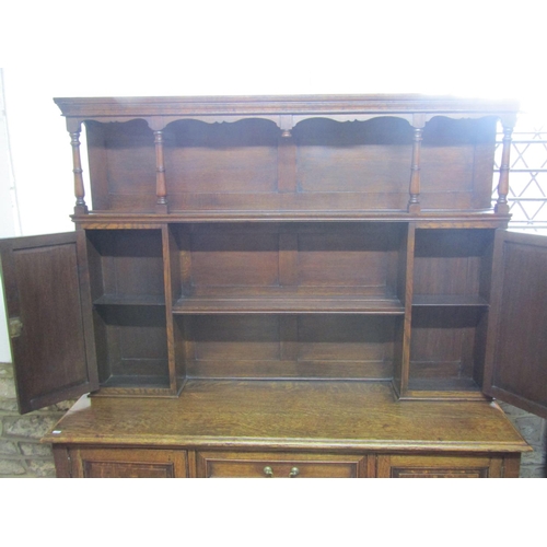 1286 - An Edwardian oak dresser the lower section enclosed by three central doors flanked by two cupboards,... 