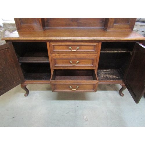 1286 - An Edwardian oak dresser the lower section enclosed by three central doors flanked by two cupboards,... 