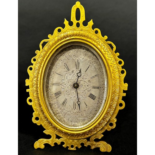 519 - Engraved gilt easel clock in the manner of Thomas Cole, the silvered dial finely engraved with folia... 