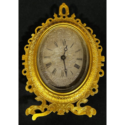 519 - Engraved gilt easel clock in the manner of Thomas Cole, the silvered dial finely engraved with folia... 