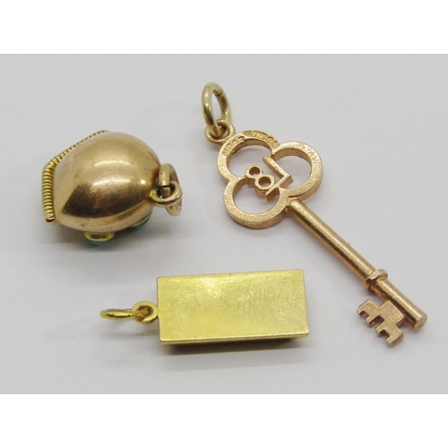 315 - Three small gold charms / pendants comprising a 9k ingot, a 9ct 18th birthday key and a bell set wit... 