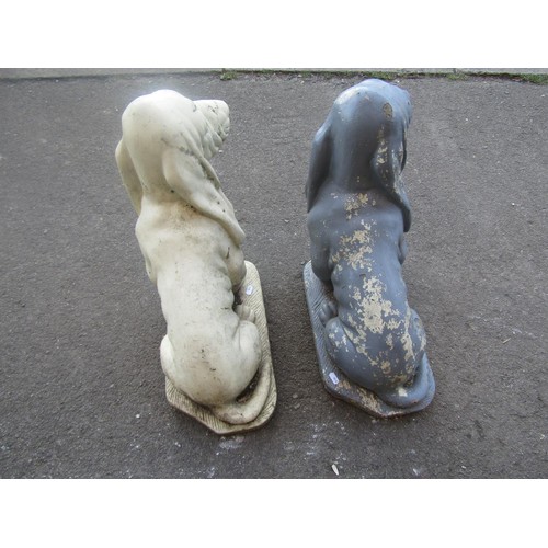 1036 - A matched pair of painted cast composition stone garden ornaments in the form of seated basset like ... 