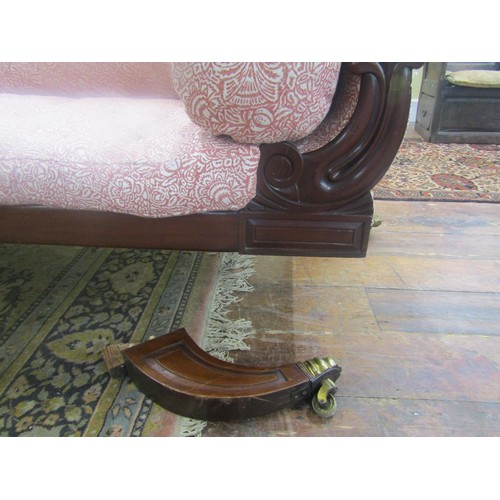 1435 - A Regency mahogany sabre leg settee with carved detail and later upholstered finish, 210cm long